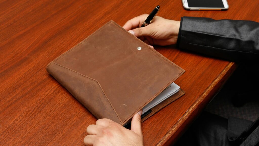 A businessman jotting down ideas in a leather notebook