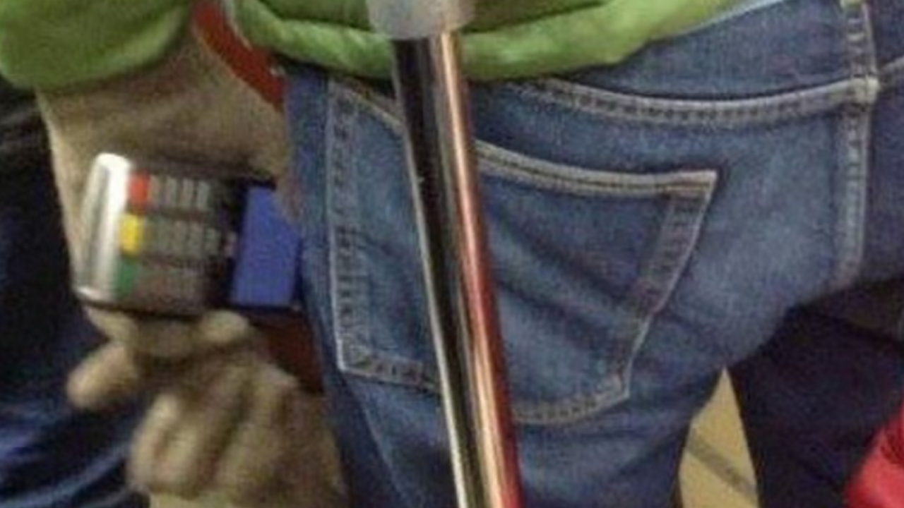 A person using a cane is holding a cell phone.