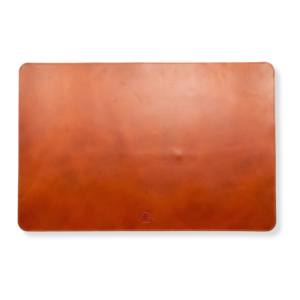 A smooth brown leather desk mat with rounded corners and visible stitching