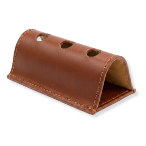 Brown leather desk pen holder with curved design, three holes on top.