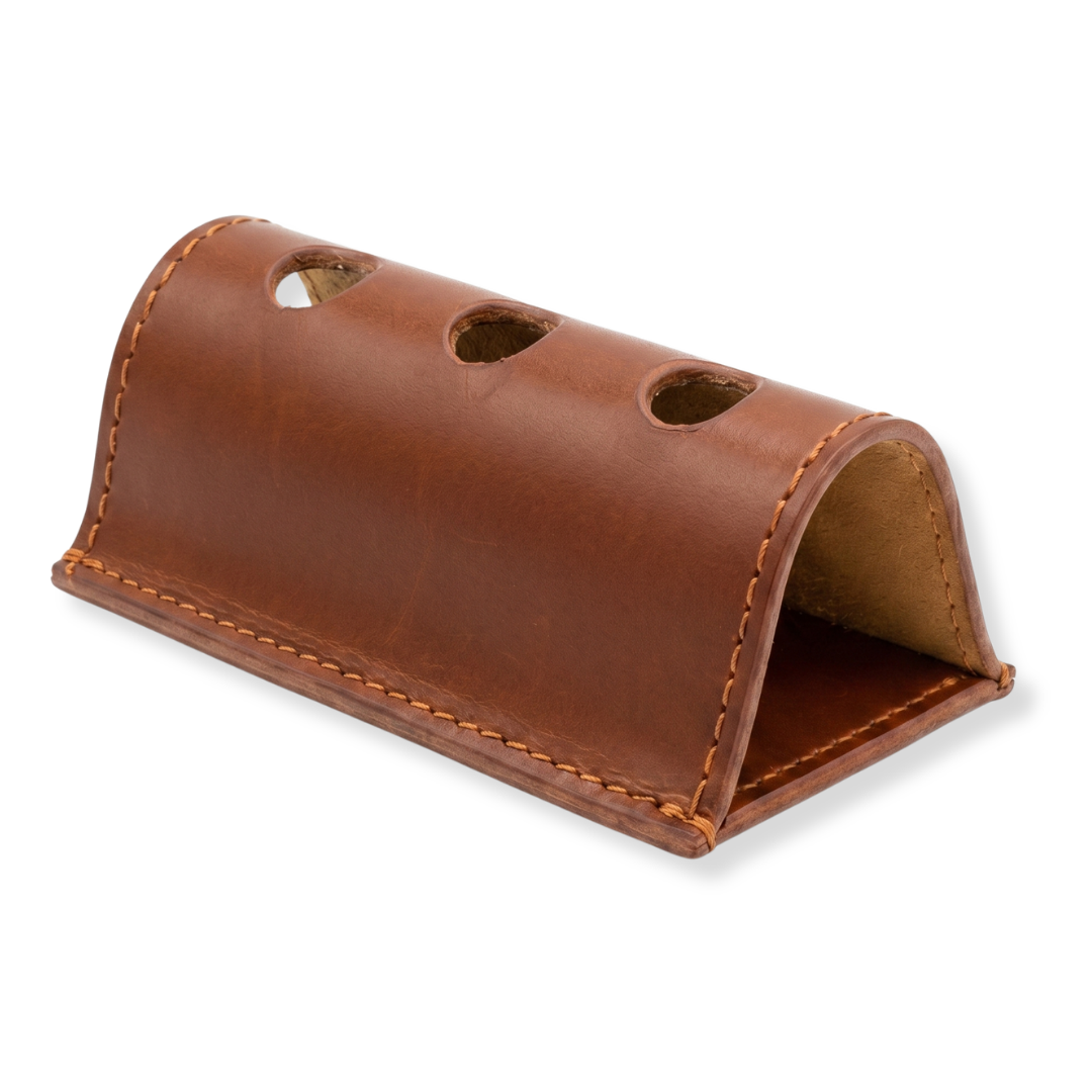 Brown leather desk pen holder with curved design, three holes on top.