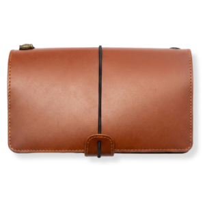 A brown leather travel journal with a black elastic band closure.